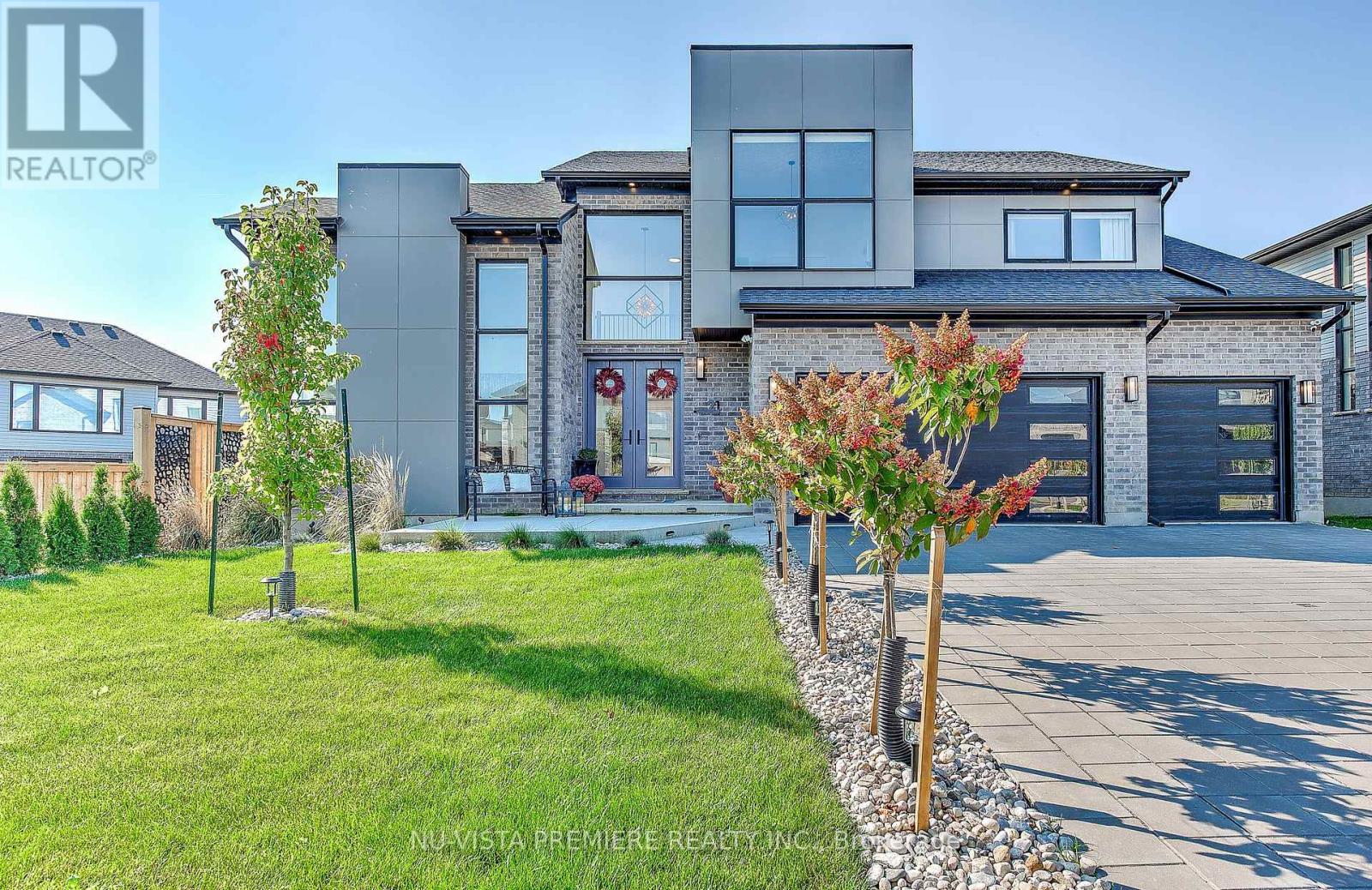 Welcome to 21 Locky Lane, a modern masterpiece with unbeatable curb appeal and thoughtful design throughout. This 3-car garage home sits proudly on a beautifully landscaped lot and offers exceptional outdoor space, including both backyard and side yard areas perfect for entertaining or relaxing. Inside, you're greeted by soaring ceilings, oversized windows, and a layout designed for modern living.  Designed for families and executive professionals, this home is a showstopper from the moment you step inside. The grand foyer sets the tone with soaring ceilings and sleek glass panels, leading into the breathtaking den, where floor-to-ceiling windows flood the space with natural light. A  fireplace and feature wall stretches elegantly to the ceiling, complemented by custom cabinetry and designer lighting. The chefs kitchen is a dream come true, boasting sleek quartz countertops, a built-in pantry, and premium Fisher & Paykel appliances perfect for everything from intimate dinners to lavish entertaining. Upstairs, the primary suite is pure luxury, with an oversized walk-through closet and expansive windows. The ensuite rivals a high-end spa, offering a tranquil retreat at the end of the day. Two additional spa-like bathrooms, including a Jack and Jill bath, ensure convenience and style for the whole family. No detail has been overlooked, from the fully upgraded mudroom to motorized blinds controlled with a smartphone app for effortless ambiance. Outside, landscaped gardens and a fully fenced backyard create a private oasis. A covered patio with pull-down blinds makes for the perfect summer escape, whether you're hosting or unwinding. The 3-car garage and extended driveway provide ample space for vehicles, guests, and all your storage needs. Nestled in a serene community just minutes from top-rated schools, parks, and shopping, this home offers the perfect blend of grandeur and practicality. (id:48254)