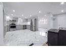 Kitchen with under cabinet range hood, marble finish floor, appliances with stainless steel finishes, and gray cabinetry