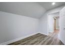 Additional living space with vaulted ceiling, wood finished floors, and baseboards