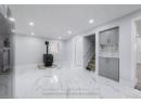 Basement with stairway, marble finish floor, a wood stove, and baseboards
