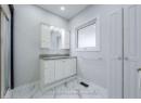 Full bath featuring marble finish floor, vanity, and baseboards