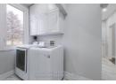 Washroom featuring baseboards, cabinet space, marble finish floor, and washer and clothes dryer