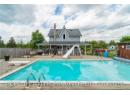 View of pool with a fenced in pool, a water slide, fence, a wooden deck, and a diving board