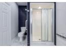 Full bathroom featuring marble finish floor, vanity, toilet, and a shower stall