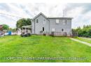 Back of property featuring a yard, a wooden deck, and fence