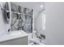 Bathroom with bath / shower combo with glass door, toilet, marble finish floor, vanity, and a baseboard radiator