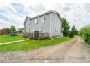 Back of property with a wooden deck and a yard