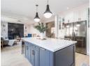 Kitchen with freestanding refrigerator, white cabinets, light wood-style flooring, glass insert cabinets, and light countertops