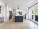 Kitchen featuring a center island, light wood-type flooring, white cabinets, light countertops, and recessed lighting