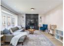 Living room with light wood-type flooring, recessed lighting, and a premium fireplace