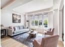 Living area with light wood-style floors, recessed lighting, and a raised ceiling