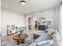Living area with light wood finished floors and recessed lighting