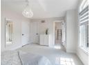 Unfurnished bedroom with a chandelier and light carpet