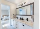 Bathroom featuring double vanity, connected bathroom, and tile patterned flooring