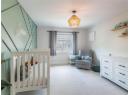 Bedroom featuring light colored carpet and a crib
