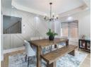 Dining space featuring a chandelier, a decorative wall, stairs, light wood-type flooring, and recessed lighting