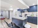 Kitchen featuring blue cabinetry, light wood-style floors, tasteful backsplash, and recessed lighting