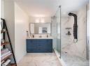 Bathroom with marble look tiles, a marble finish shower, double vanity, and recessed lighting