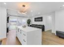 Kitchen with recessed lighting, light wood finished floors, white cabinets, a center island, and hanging light fixtures