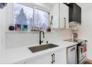 Kitchen featuring stainless steel appliances, backsplash, exhaust hood, light countertops, and white cabinets