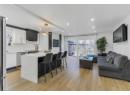 Kitchen with light countertops, a kitchen bar, light wood-style floors, white cabinetry, and recessed lighting