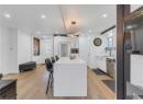 Kitchen featuring white cabinets, modern cabinets, light wood-style floors, a center island, and recessed lighting