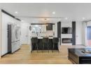 Kitchen with light countertops, freestanding refrigerator, a breakfast bar area, light wood finished floors, and recessed lighting