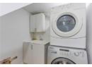 Laundry area featuring stacked washing machine and dryer and cabinet space