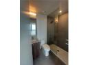 Full bath with vanity, a walk in shower, and dark tile patterned flooring