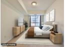 Bedroom with a textured ceiling and wood finished floors