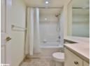Bathroom featuring shower / tub combo with curtain, vanity, and light tile patterned floors