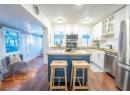Kitchen with sink, stainless steel appliances, wood counters, a kitchen bar, and white cabinets