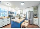 Kitchen with wood counters, dark hardwood / wood-style flooring, stainless steel appliances, a center island, and white cabinetry
