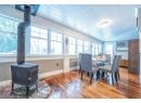 Dining area with a wood stove, a healthy amount of sunlight, wooden ceiling, and hardwood / wood-style flooring