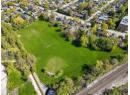 Aerial view of property and surrounding area featuring nearby suburban area