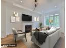Living room featuring light wood-type flooring, a fireplace with flush hearth, and recessed lighting