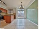 Kitchen with appliances with stainless steel finishes, hanging light fixtures, dark stone counters, a center island, and a chandelier