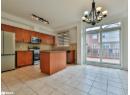 Kitchen with appliances with stainless steel finishes, pendant lighting, a center island, dark stone counters, and light tile patterned floors
