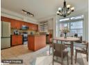 Kitchen with appliances with stainless steel finishes, pendant lighting, light tile patterned floors, a center island, and dark stone countertops