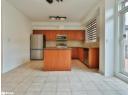 Kitchen with stainless steel appliances, dark stone countertops, a kitchen island, light tile patterned floors, and tasteful backsplash