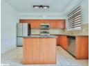 Kitchen with dark stone counters, stainless steel appliances, a kitchen island, and backsplash
