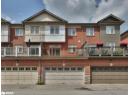 Back of house with brick siding, a balcony, and an attached garage