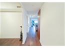 Hallway with dark wood-type flooring and baseboards
