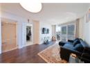 Living area with a textured ceiling, wood finished floors, and a wall of windows
