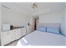 Carpeted bedroom with a tray ceiling