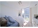 Bedroom featuring light colored carpet and floor to ceiling windows