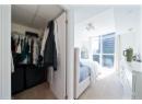 Bedroom featuring light carpet, a closet, a drop ceiling, and a wall of windows