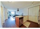 Kitchen featuring a peninsula, floor to ceiling windows, dishwasher, dark wood finished floors, and open floor plan
