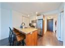 Kitchen with a kitchen bar, appliances with stainless steel finishes, a peninsula, rail lighting, and dark wood-type flooring