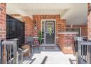 Property entrance featuring brick siding and covered porch